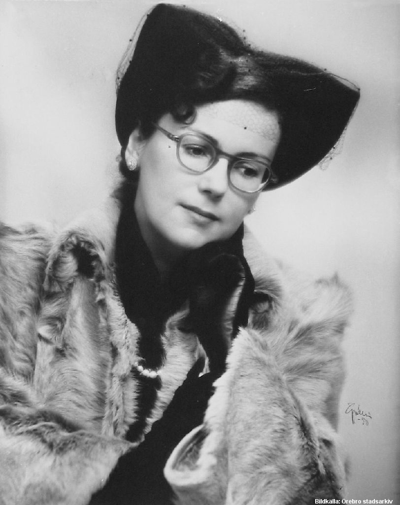 Kvinna med hatt, päls och glasögon.
