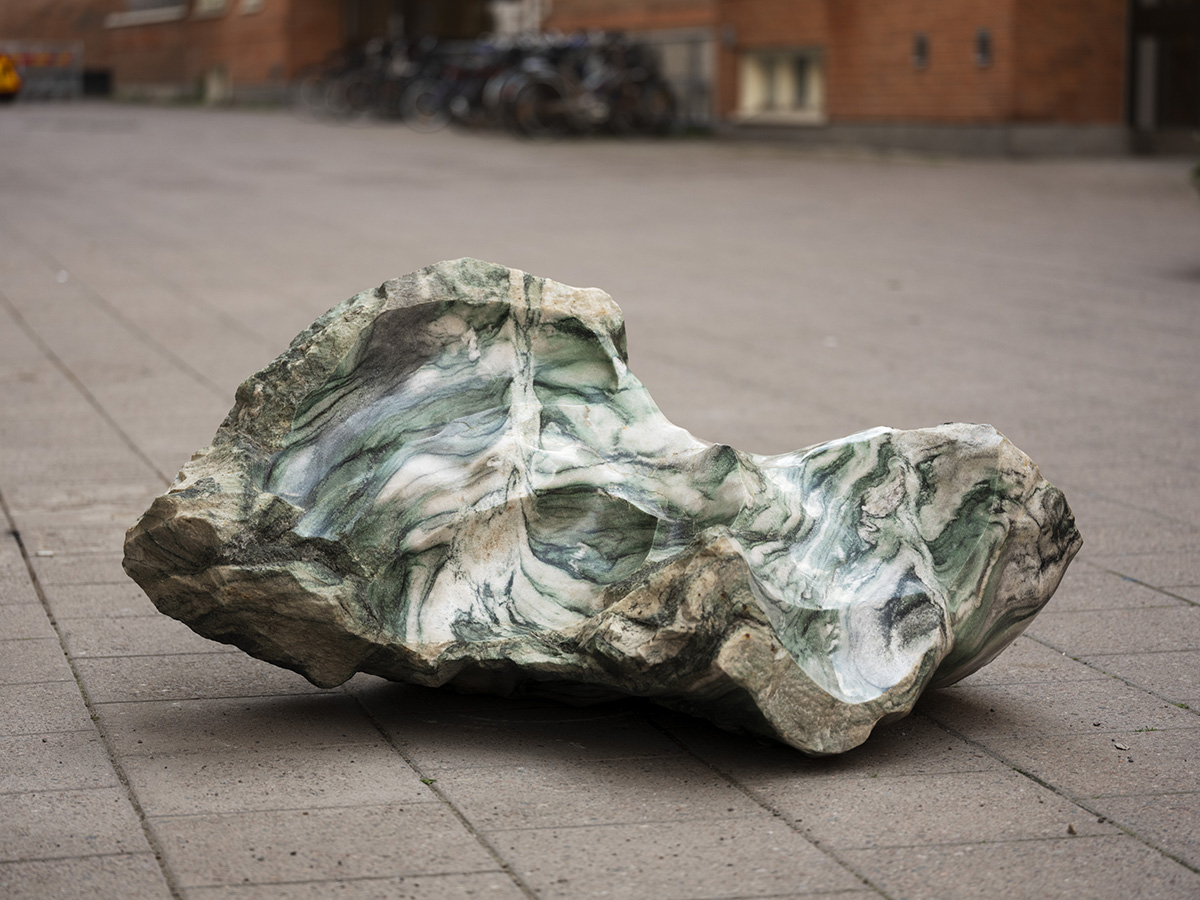 En abstrakt granitskulptur är placerad på en gata 