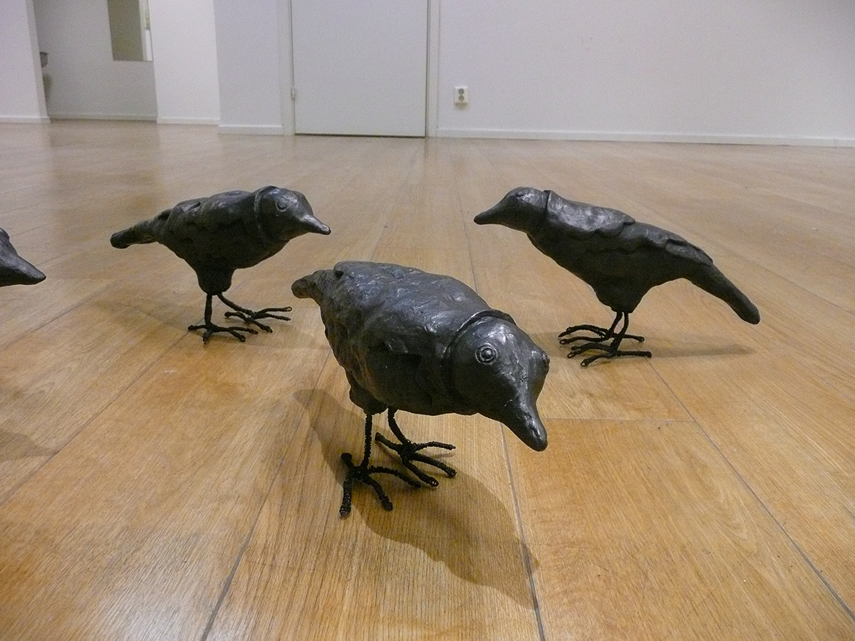 På golvet står tre statyer föreställandes kråkor.