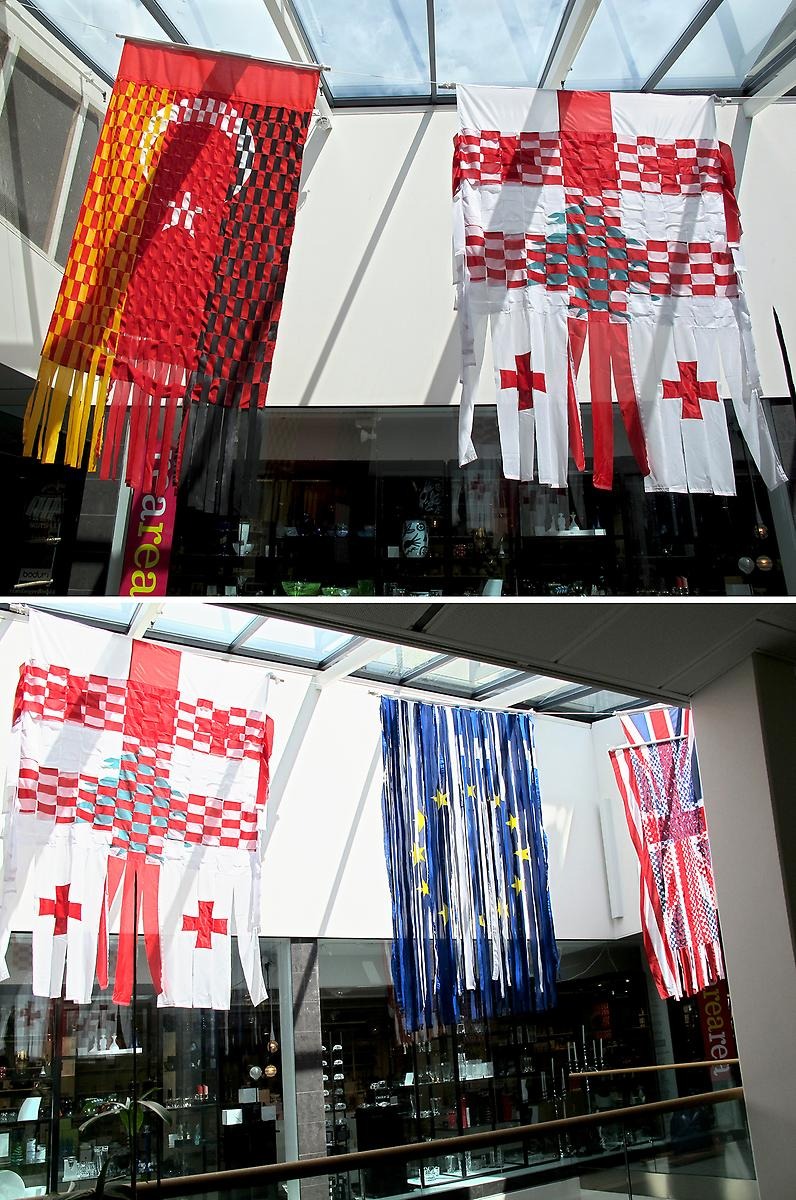 Nationella flaggor har klippts sönder och flätats samman och hänger ner från taket.