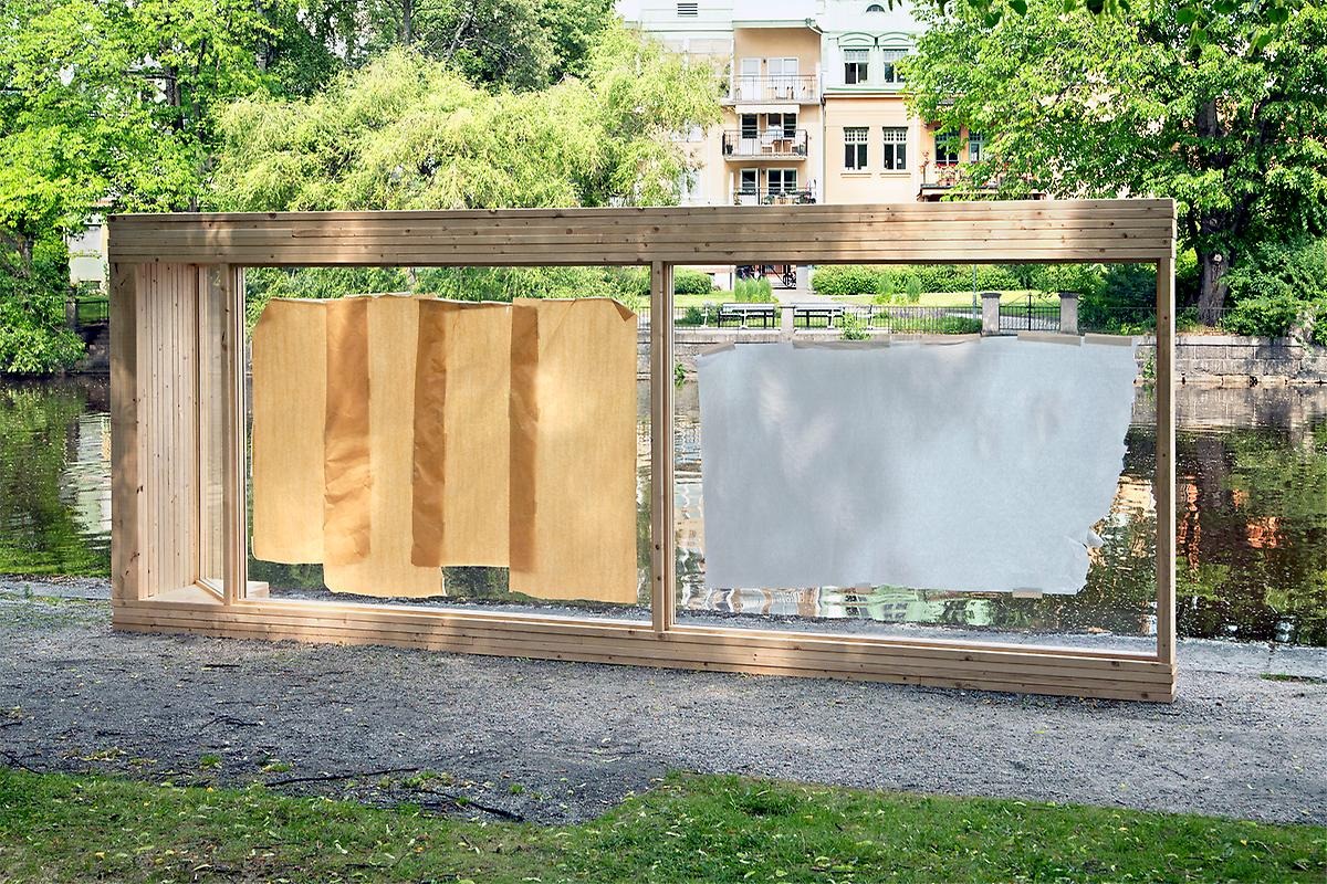 Längs Svartån står en 100 meter rektangelformad träram, i mitten sitter dubbla glas och inuti dem sitter skydds-papper i vit och brun färg. 