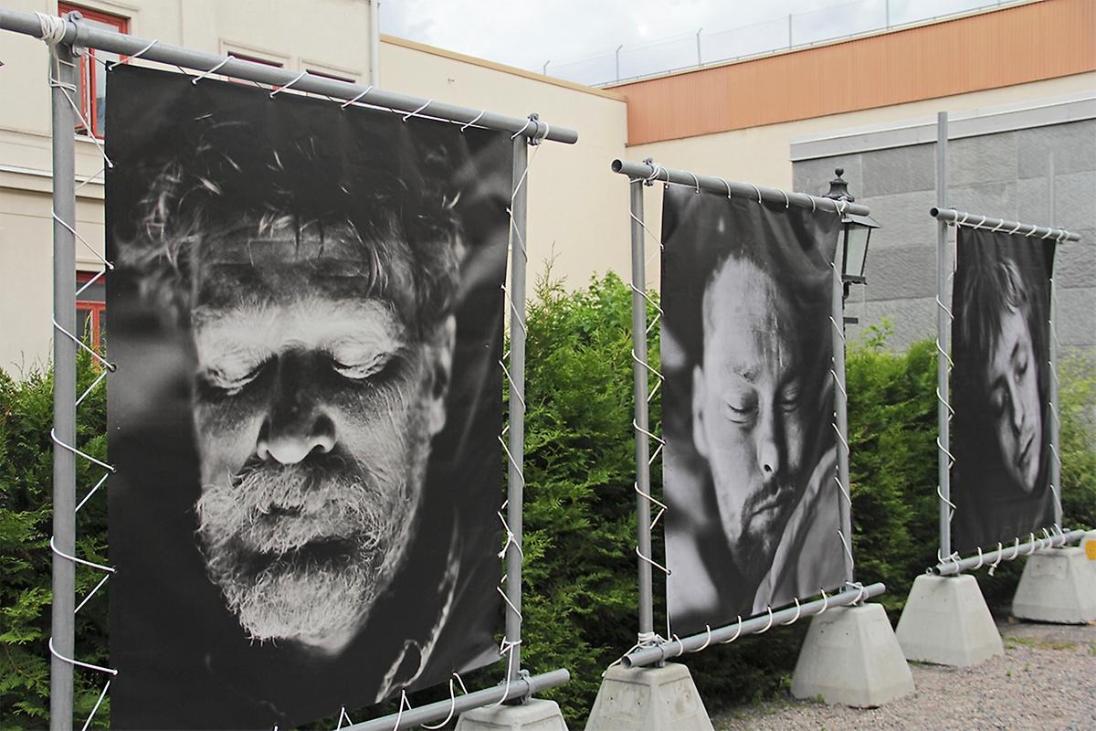 På två betongsuggor håller upp en stålram och i den hänger ett svartvitt fotografi. Tre sådana konstruktioner står på rad och fotografierna föreställer tre sovande hemlösa köpenhamnsbor vars porträtt i en försvarslös position.