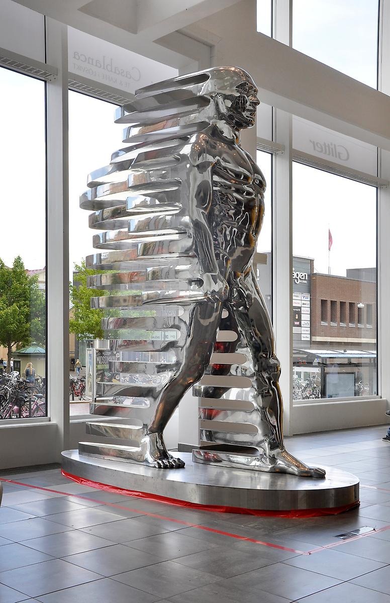 Inne i gallerian Krämaren står en gigantisk silver färgad skulptur. Skulpturen föreställer en naken man i farten då baksidan av hela hans kropp utformas till utdragna streck. 