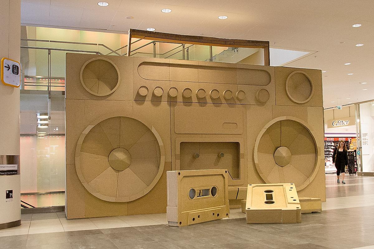Inne i gallerian Krämaren står en gigantisk analog radio från 80-talet och framför står två enormare kassettband. Alla skapelserna se ut att vara gjorda i wellpap och har samma orginalfärg.