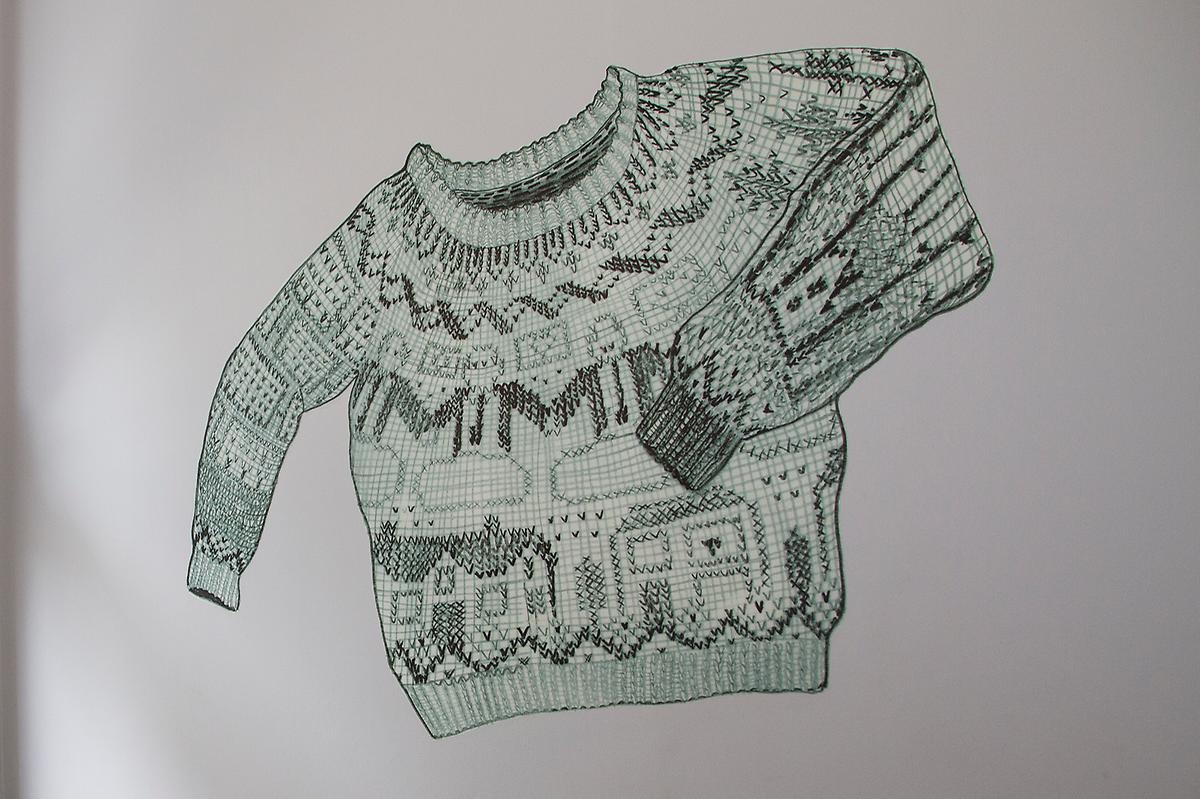 En teckning av en mysig tröja som är utformad av ljus och mörkgröna korsstygn.