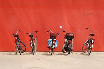 Cyklar parkerade mot röd vägg